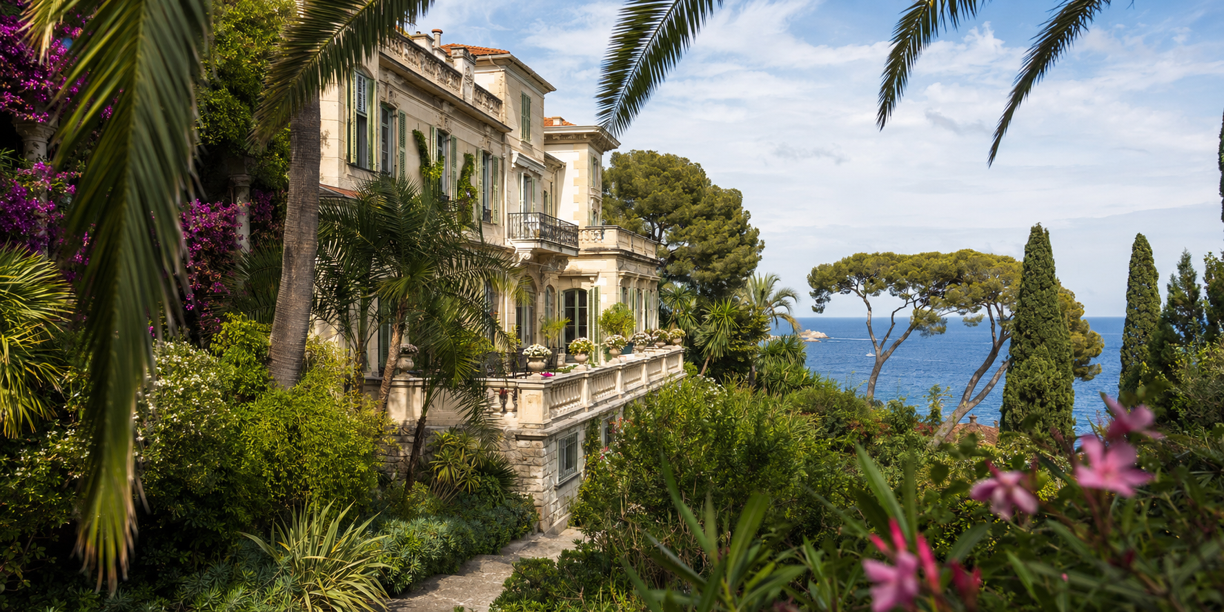Rocky coastline with structures overlooking a sparkling blue ocean.
